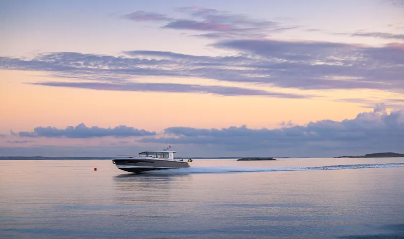 Slide: The Image of Nimbus Commuter 11 boat cruising at sunset, 2026 model, serene ocean view. - 38