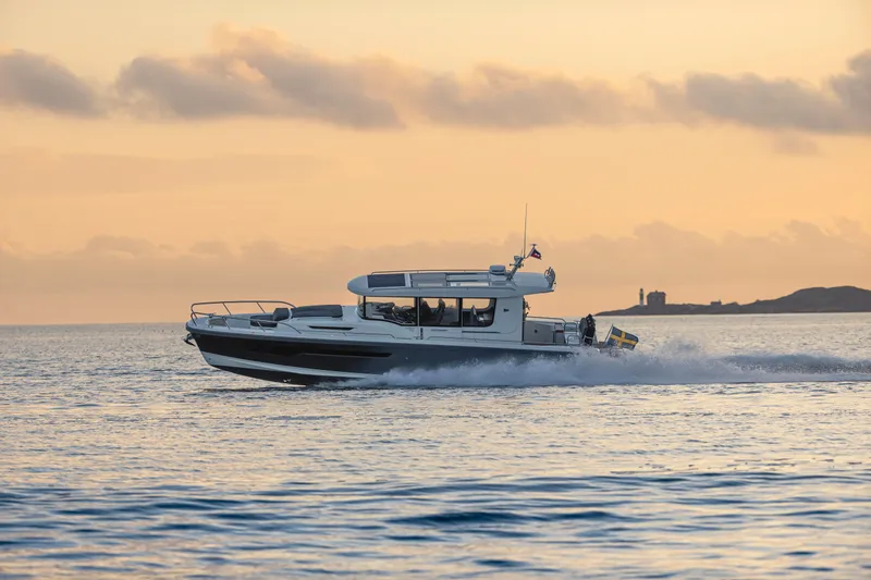 Slide: The Image of Nimbus Commuter 11 (2026) cruising at sunset on calm waters. - 4
