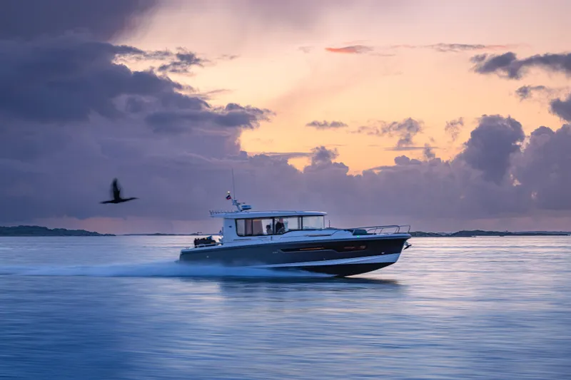 Slide: The Image of Nimbus Commuter 11 boat cruising at sunset, 2026 model, with serene ocean backdrop. - 40