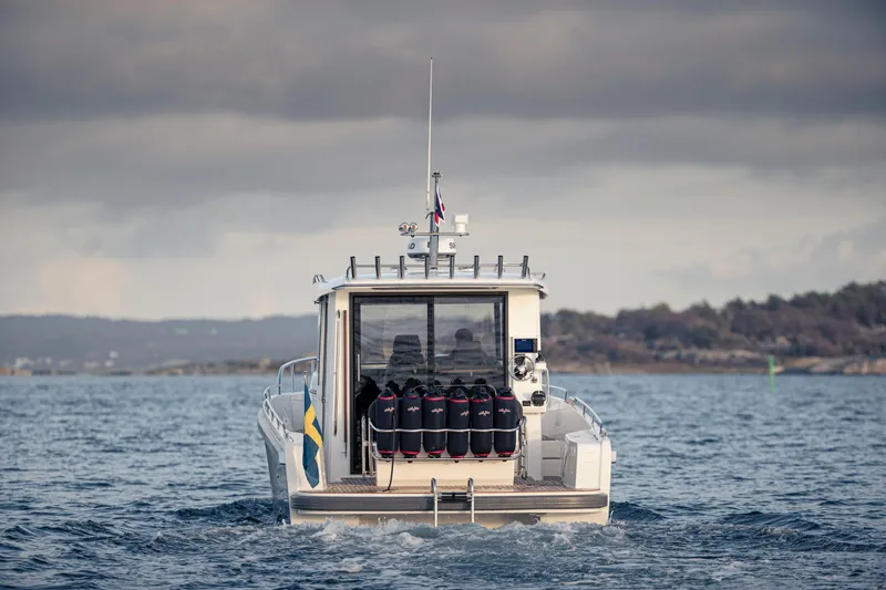 Slide: The Image of Nimbus Commuter 11 boat, 2026 model, cruising on open water under cloudy skies. - 6