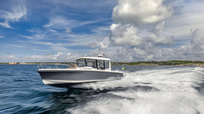 Slide: The Image of 2025 Nimbus Commuter 8 boat cruising on open water under a cloudy sky. - 15