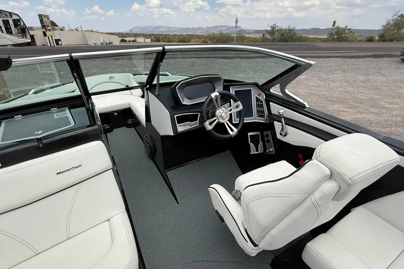 Slide: The Image of 2018 MasterCraft XT25 boat interior with modern dashboard and white seating. - 14