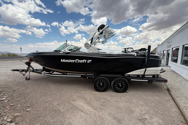 Slide: The Image of 2018 MasterCraft XT25 boat on trailer under cloudy sky. - 4