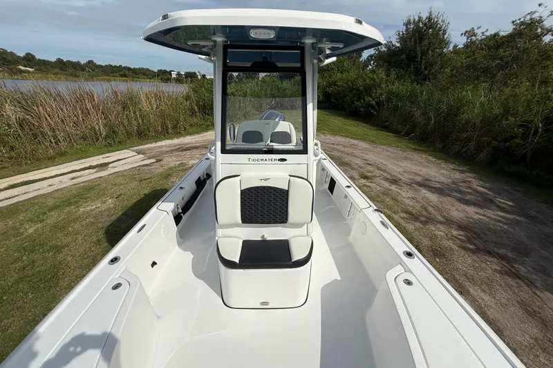 Slide: The Image of 2026 Tidewater 2410 Bay Max boat with sleek design, parked near a grassy area. - 18