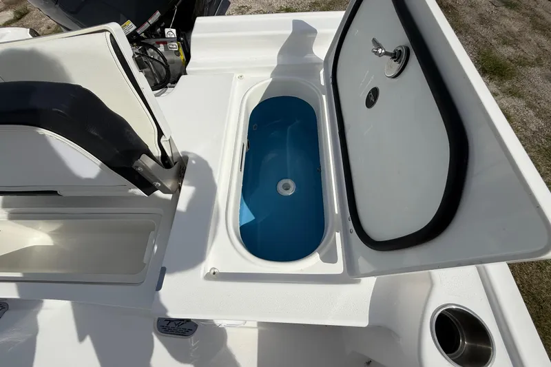 Slide: The Image of Open storage compartment on 2026 Tidewater 2410 Bay Max boat, featuring a blue interior. - 26