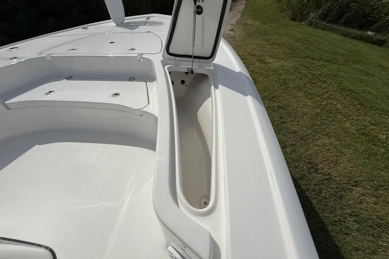 Slide: The Image of 2026 Tidewater 2410 Bay Max boat with open storage compartment on grassy area. - 38