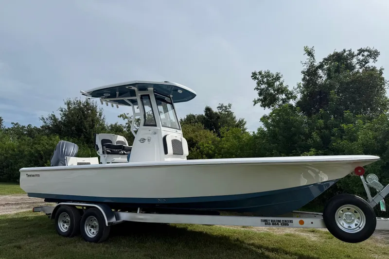 Slide: The Image of 2026 Tidewater 2410 Bay Max boat on trailer, surrounded by greenery. - 8