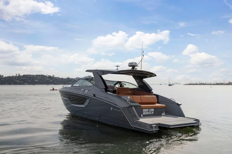 Slide: The Image of 2022 Cruisers Yachts 38 GLS South Beach IO on calm water under blue sky. - 1