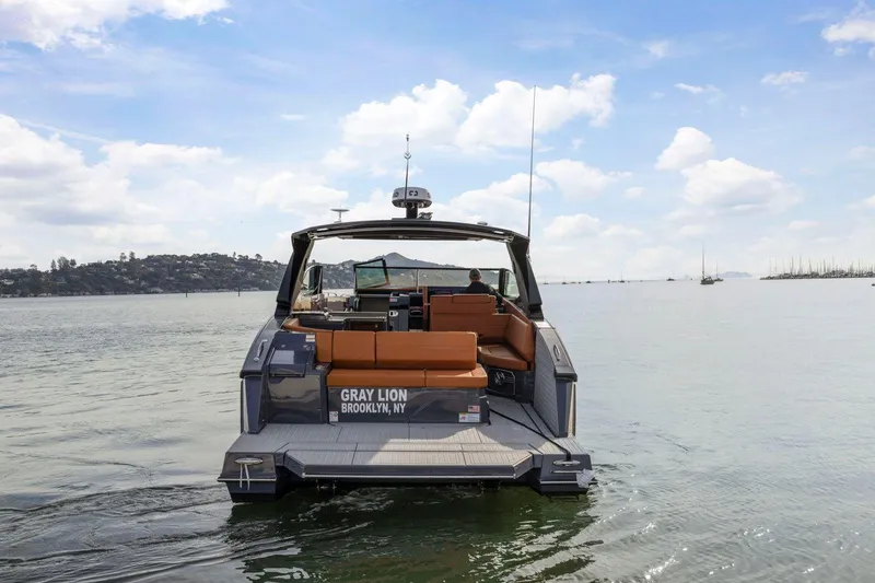 Slide: The Image of 2022 Cruisers Yachts 38 GLS South Beach IO on calm water, rear view. - 2