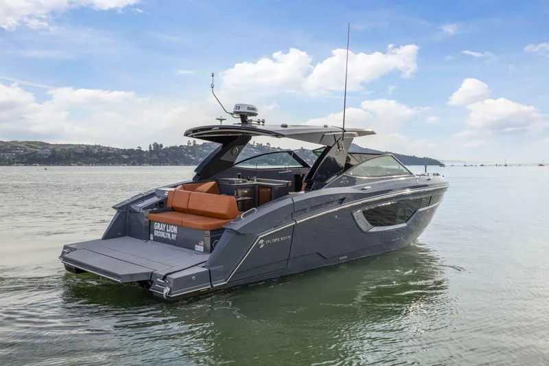Slide: The Image of 2022 Cruisers Yachts 38 GLS South Beach IO on calm water, showcasing sleek design and luxury features. - 3