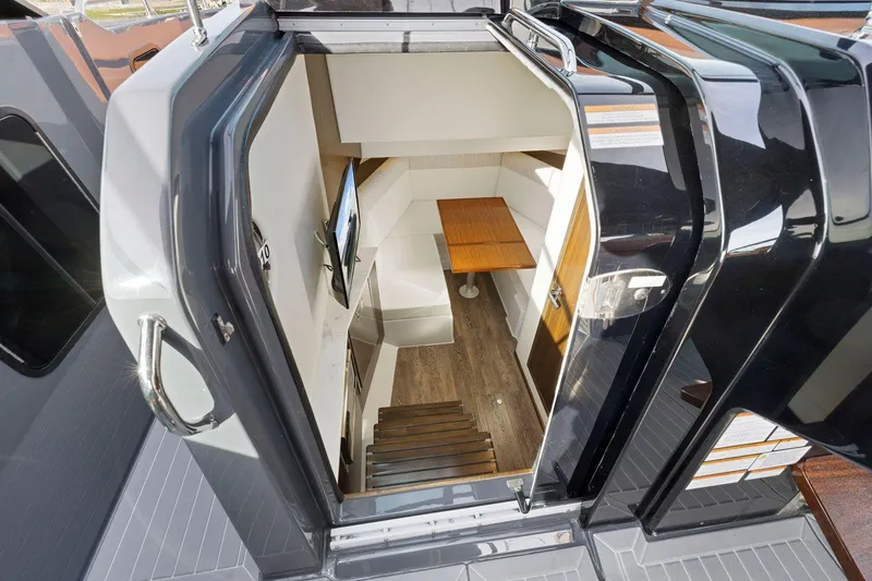 Slide: The Image of Interior view of 2022 Cruisers Yachts 38 GLS South Beach IO, featuring stairs and a compact dining area. - 34
