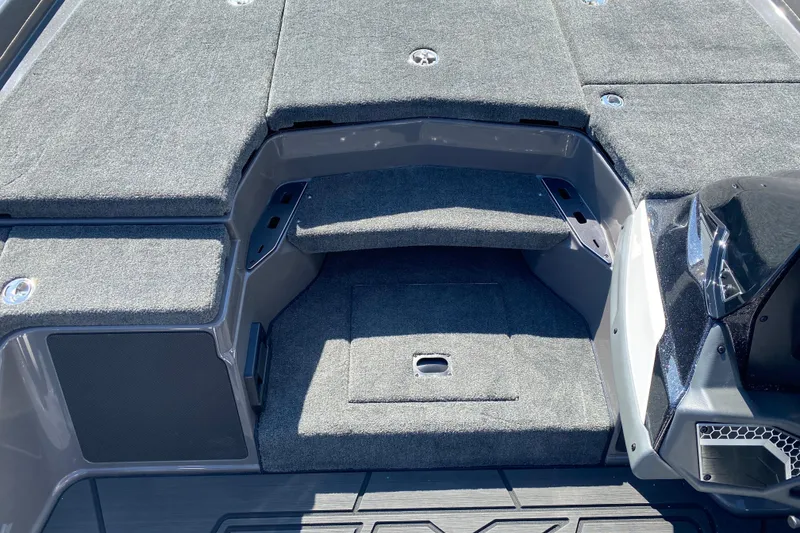 Slide: The Image of 2026 Skeeter FXR21 FLEX boat interior with gray carpeted deck and storage compartments. - 11