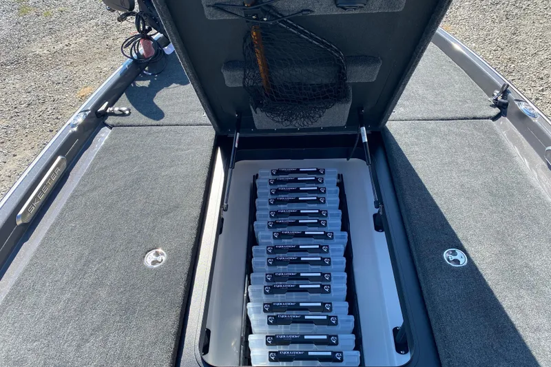 Slide: The Image of 2026 Skeeter FXR21 FLEX boat with open storage compartment and organized tackle boxes. - 17