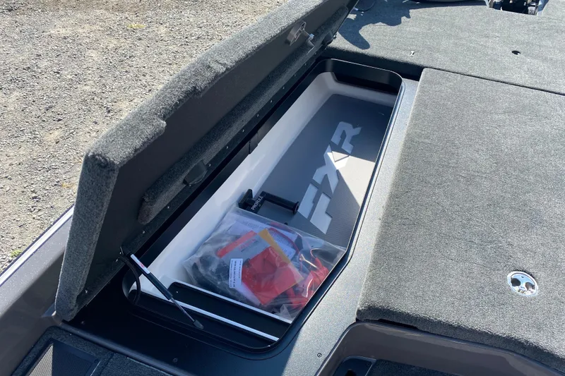 Slide: The Image of Open storage compartment in 2026 Skeeter FXR21 FLEX boat, showing interior space and accessories. - 18