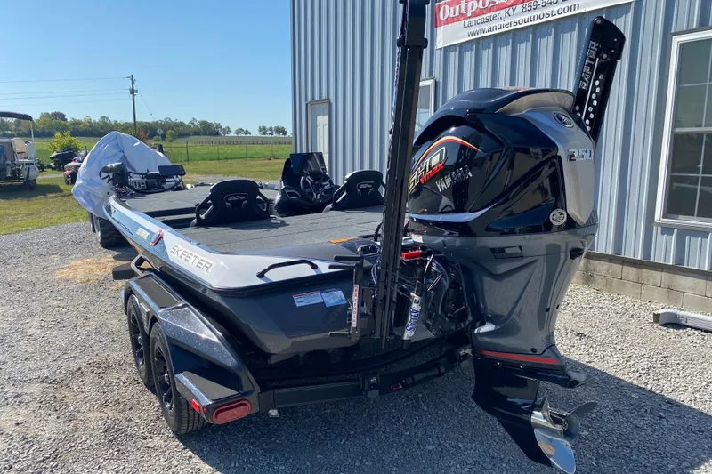 Slide: The Image of 2026 Skeeter FXR21 FLEX boat with Yamaha engine, parked outdoors near a building. - 7