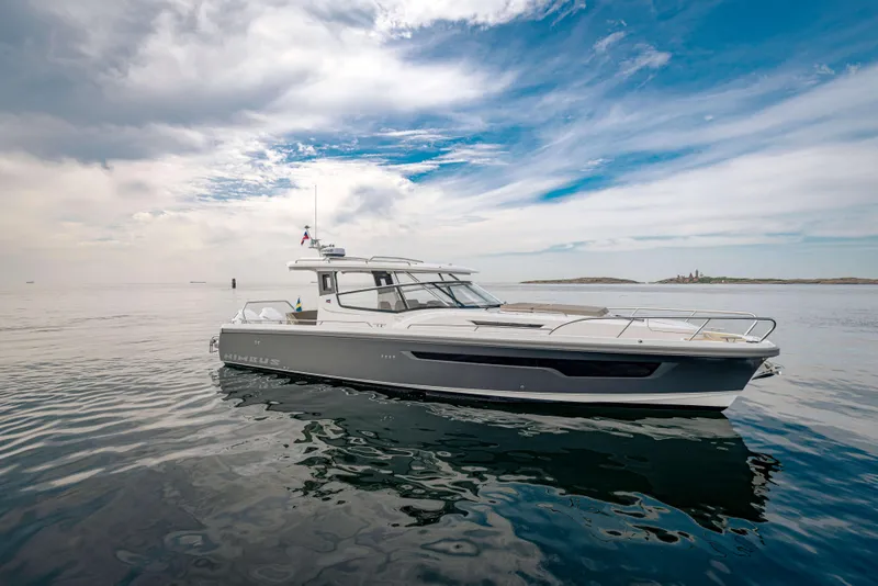 Slide: The Image of 2025 Nimbus Weekender 11 yacht on calm water under a partly cloudy sky. - 41