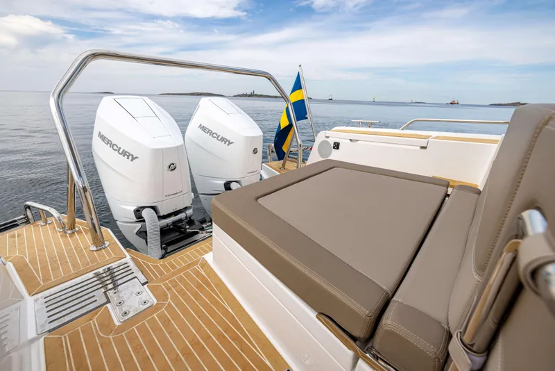 Slide: The Image of 2025 Nimbus Weekender 11 boat with twin Mercury engines and Swedish flag on open water. - 45