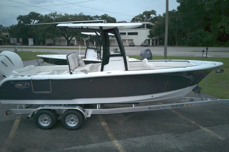 The Image of 2026 Seahunt 245 boat on trailer, parked outdoors, featuring sleek design and Yamaha engine. - 0