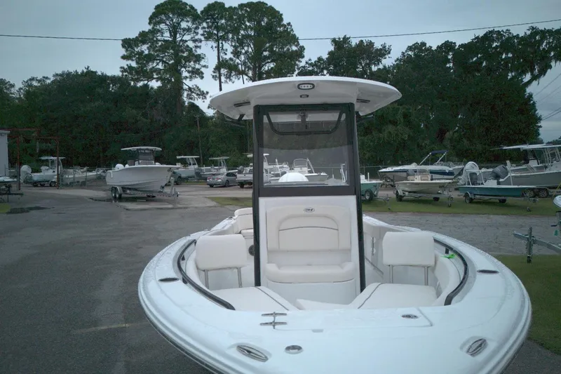 Slide: The Image of 2026 Seahunt 245 boat in a marina, surrounded by trees and other boats. - 10