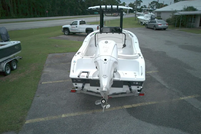 Slide: The Image of 2026 Seahunt 245 boat on trailer, parked in a lot with vehicles nearby. - 2