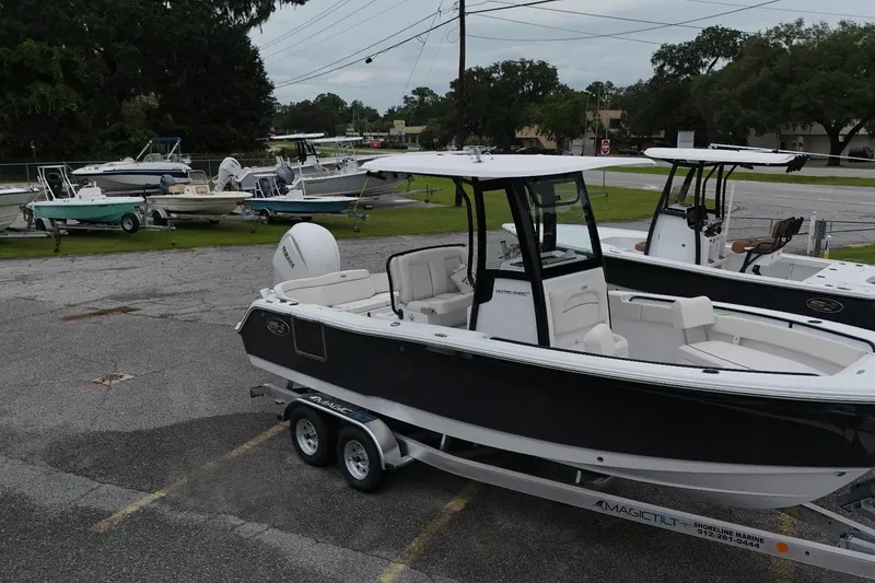 Slide: The Image of 2026 Seahunt 245 boat on trailer in parking lot, surrounded by other boats. - 4