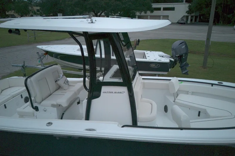 Slide: The Image of 2026 Seahunt 245 boat with seating and console, parked on grass near a trailer. - 5