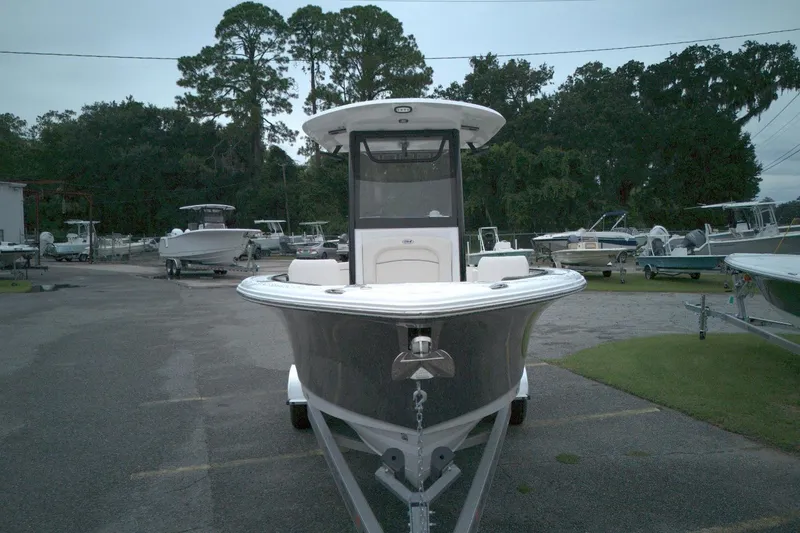 Slide: The Image of 2026 Seahunt 245 boat on trailer in marina, surrounded by trees and other boats. - 8