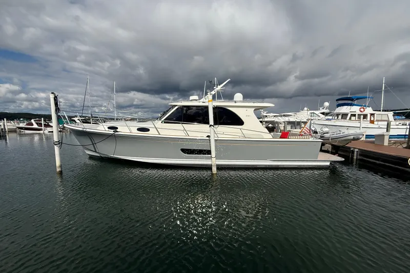 Slide: The Image of 2017 Grand Banks 44 Eastbay SX yacht docked at marina under cloudy sky. - 10