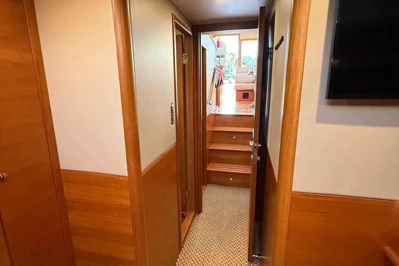 Slide: The Image of 2017 Grand Banks 44 Eastbay SX interior hallway with wooden cabinetry and bathroom view. - 106