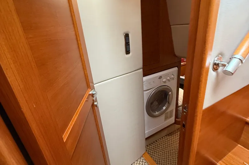 Slide: The Image of Laundry area inside 2017 Grand Banks 44 Eastbay SX yacht, featuring a compact washing machine. - 116