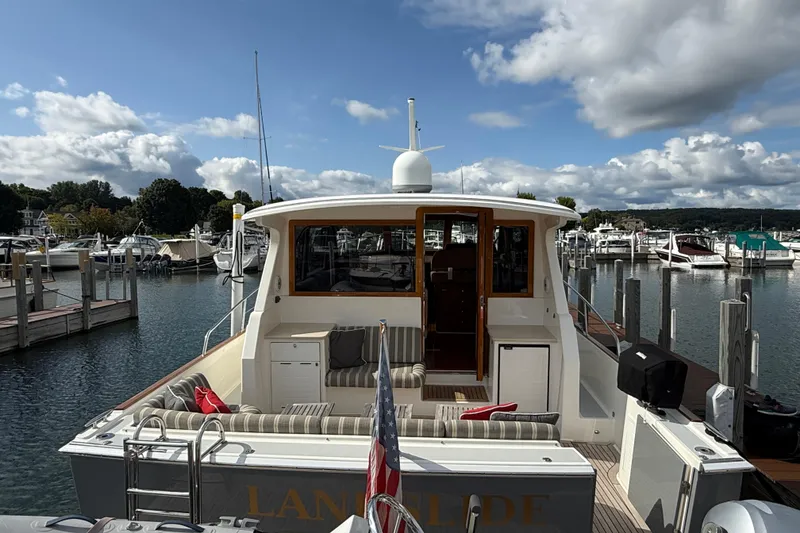 Slide: The Image of 2017 Grand Banks 44 Eastbay SX yacht docked at a marina under a partly cloudy sky. - 18