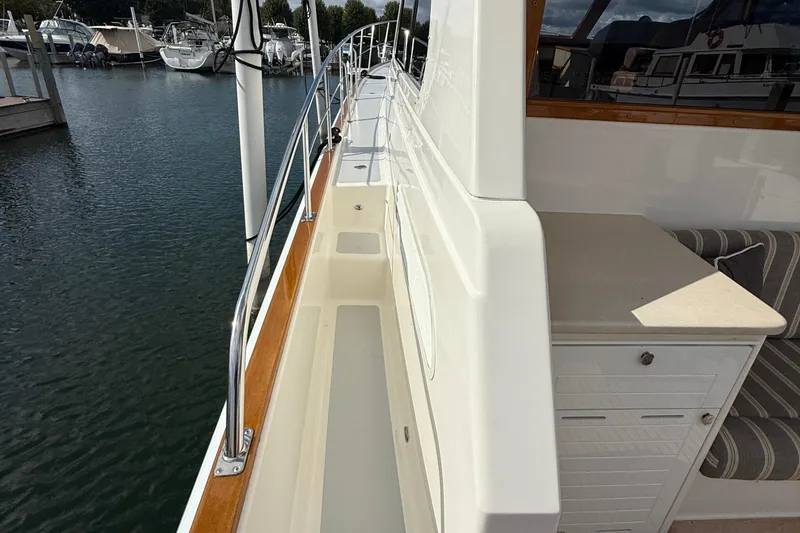 Slide: The Image of Luxurious 2017 Grand Banks 44 Eastbay SX yacht deck with striped seating and American flag. - 34