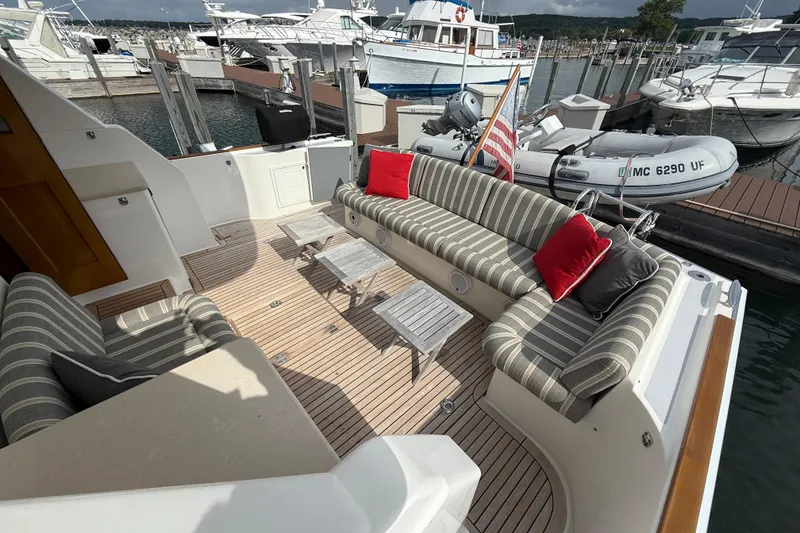 Slide: The Image of 2017 Grand Banks 44 Eastbay SX yacht interior with striped seating and wooden flooring. - 38