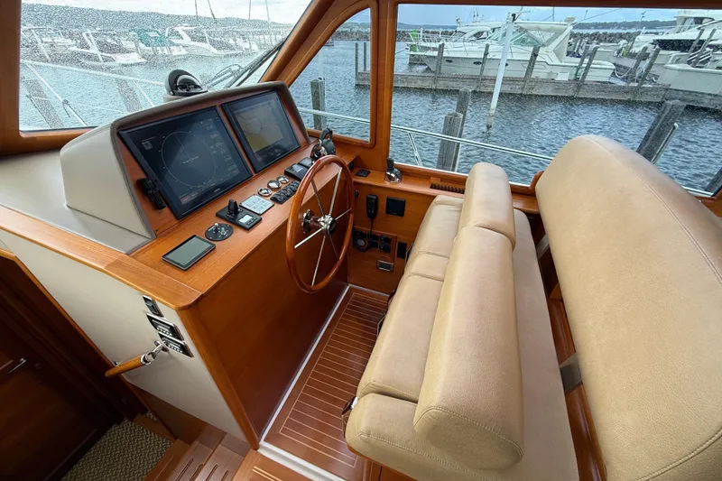 Slide: The Image of Helm of 2017 Grand Banks 44 Eastbay SX with navigation screens and wooden steering wheel. - 73