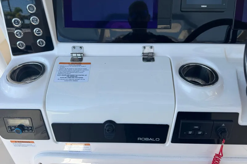 Slide: The Image of 2023 Robalo R302 Center Console dashboard with controls and cup holders. - 13
