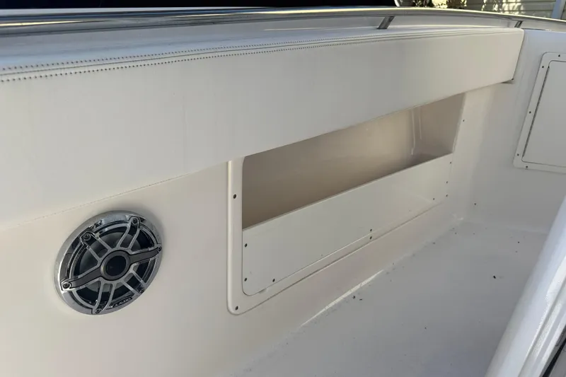 Slide: The Image of 2023 Robalo R302 Center Console boat interior with speaker and storage compartment. - 19