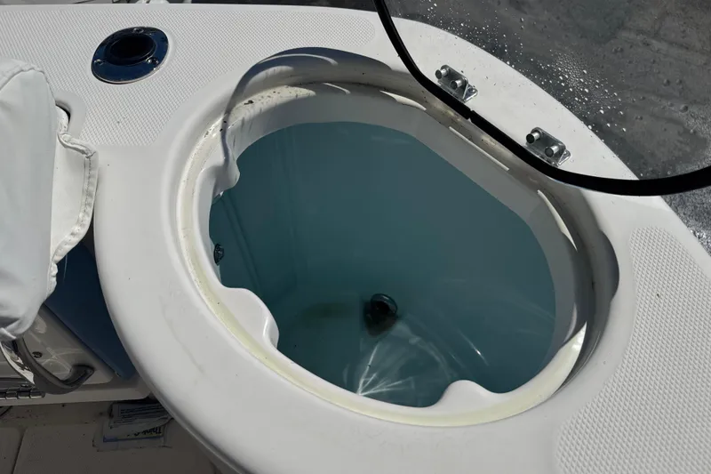 Slide: The Image of 2023 Robalo R302 Center Console livewell with open lid, showcasing interior water. - 9