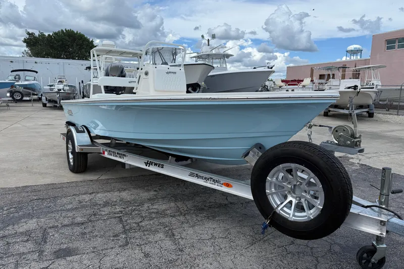 Slide: The Image of 2026 Hewes 16 Redfisher boat on trailer, parked outdoors under cloudy sky. - 10