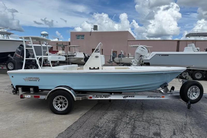 Slide: The Image of 2026 Hewes 16 Redfisher boat on trailer, displayed outdoors under cloudy sky. - 9