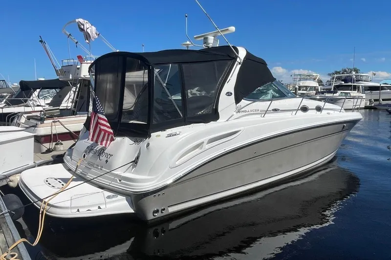 Slide: The Image of 2006 Sea Ray 360 Sundancer yacht docked at marina, featuring sleek design and American flag. - 1