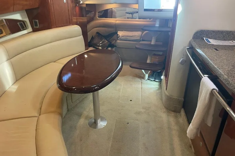 Slide: The Image of Interior of 2006 Sea Ray 360 Sundancer with beige seating and wooden table. - 27