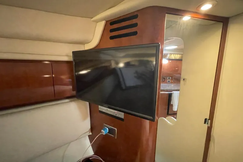 Slide: The Image of Interior of 2006 Sea Ray 360 Sundancer with mounted TV and wooden paneling. - 29