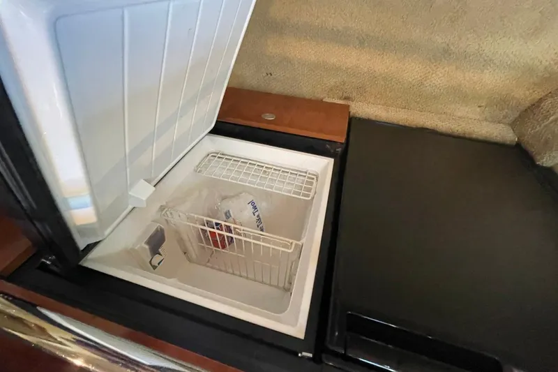 Slide: The Image of Open freezer compartment on 2006 Sea Ray 360 Sundancer yacht, showing interior storage space. - 41