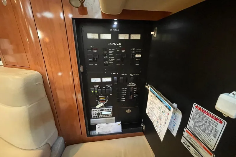 Slide: The Image of Electrical panel inside 2006 Sea Ray 360 Sundancer yacht, featuring control switches and safety instructions. - 45