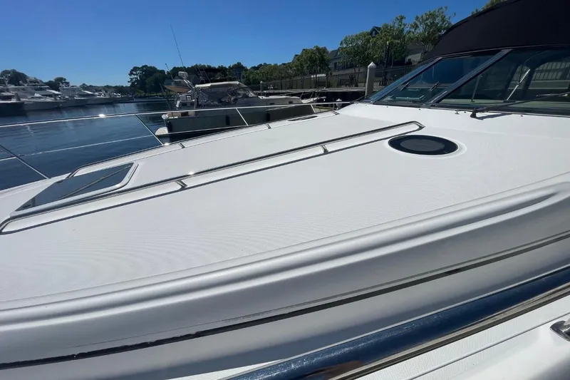 Slide: The Image of 2006 Sea Ray 360 Sundancer yacht with sunpad on deck, docked by calm water. - 51