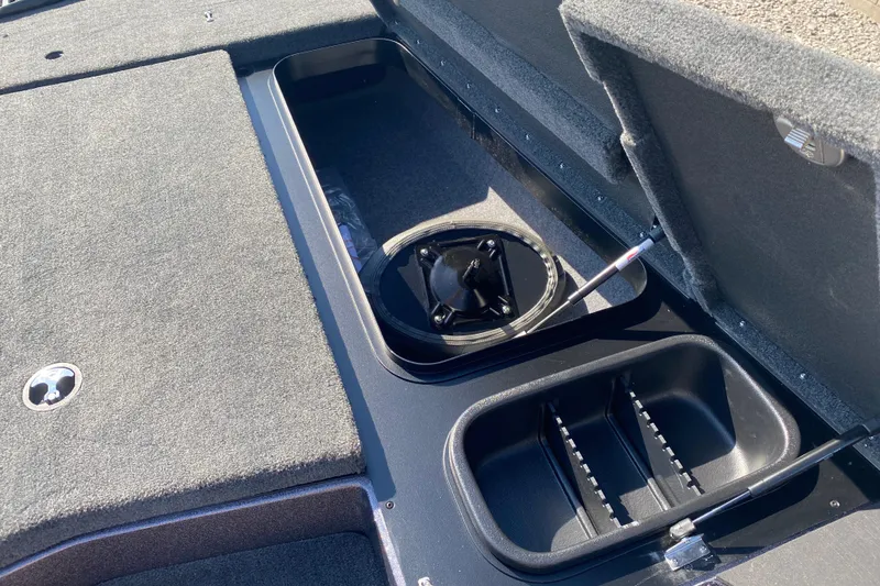 Slide: The Image of 2026 Skeeter ZX200 boat storage compartments with open lids and carpeted surfaces. - 17