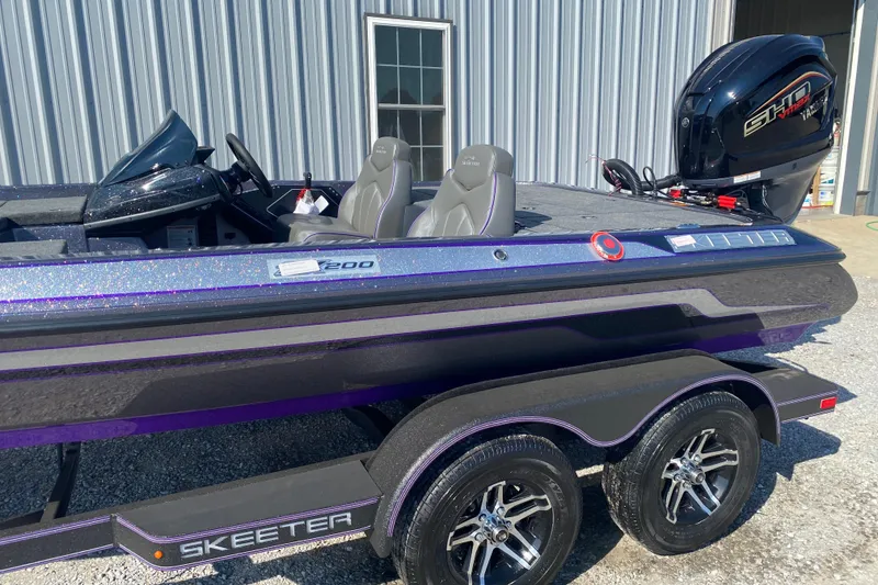 Slide: The Image of 2026 Skeeter ZX200 boat with sleek design and powerful engine, parked outside a metal building. - 7