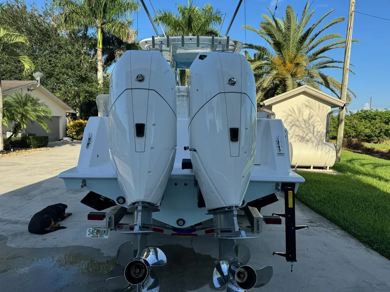 Slide: The Image of 2024 Contender 32 ST boat with dual engines, parked in a sunny driveway. - 14