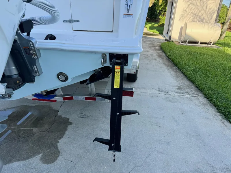 Slide: The Image of 2024 Contender 32 ST boat trailer with support jack on concrete driveway. - 15