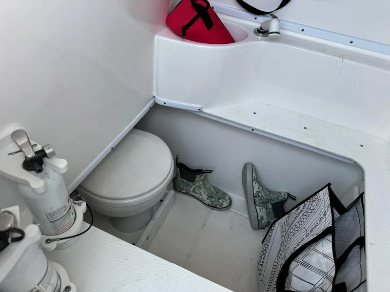 Slide: The Image of 2024 Contender 32 ST boat interior with toilet, boots, and storage items. - 5